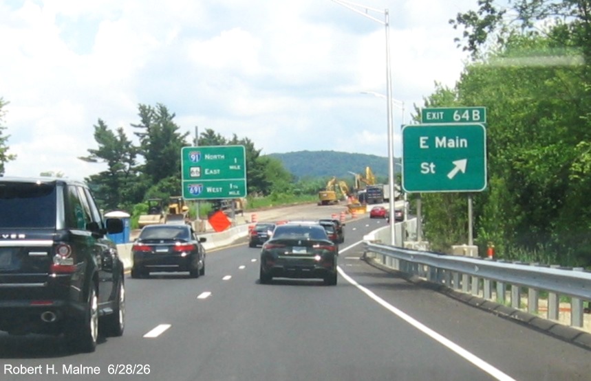 Image of ground mounted exit sign for the East Main Street exit, with
 new milepost based exit number overlay on exit tab on CT 15 North/Cross Parkway in Meriden, June 2026