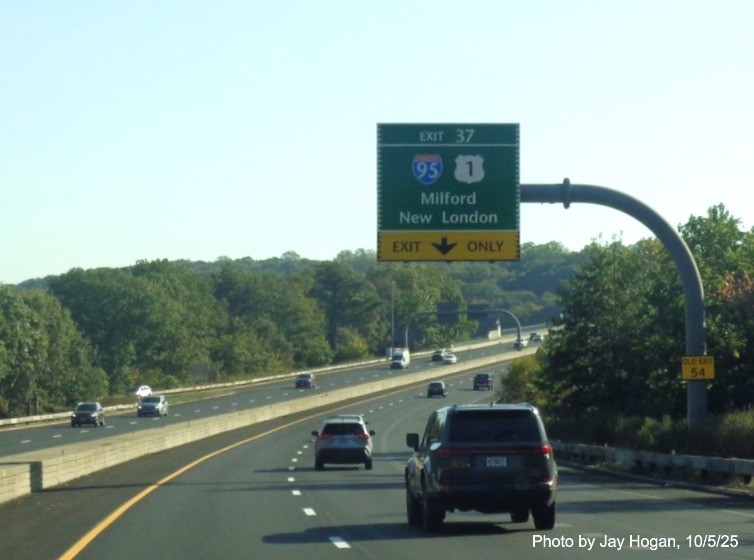 Image of 1 mile advance overhead sign for the (To) I-95/US 1 exit, with new milepost 
 based exit number and Old Exit 54 sign on support post on CT 15 North/Merritt Parkway in Stratford, by Jay Hogan, October 2025