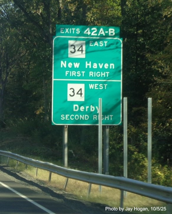 Image of ground mounted 1/2 Mile advance sign for the CT 34 exits, with new milepost 
 based exit numbers behind supports for new sign on CT 15 North/Cross Parkway in Derby, by Jay Hogan, October 2025