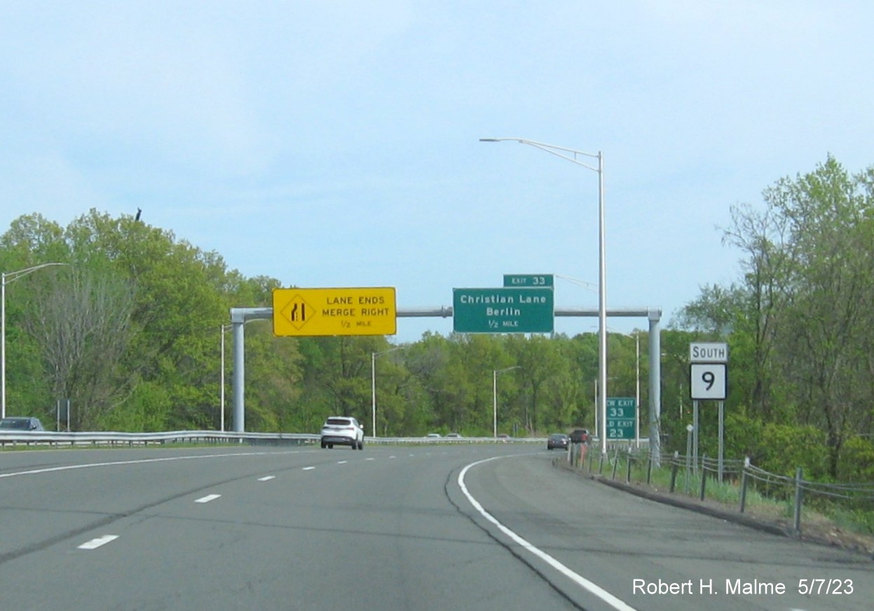 Image of 1/2 Mile advance overhead sign for Christian Lane exit with new milepost based exit number and New Exit/Old Exit 23 
      sign ground mounted in front on CT 9 South in Berlin, May 2023