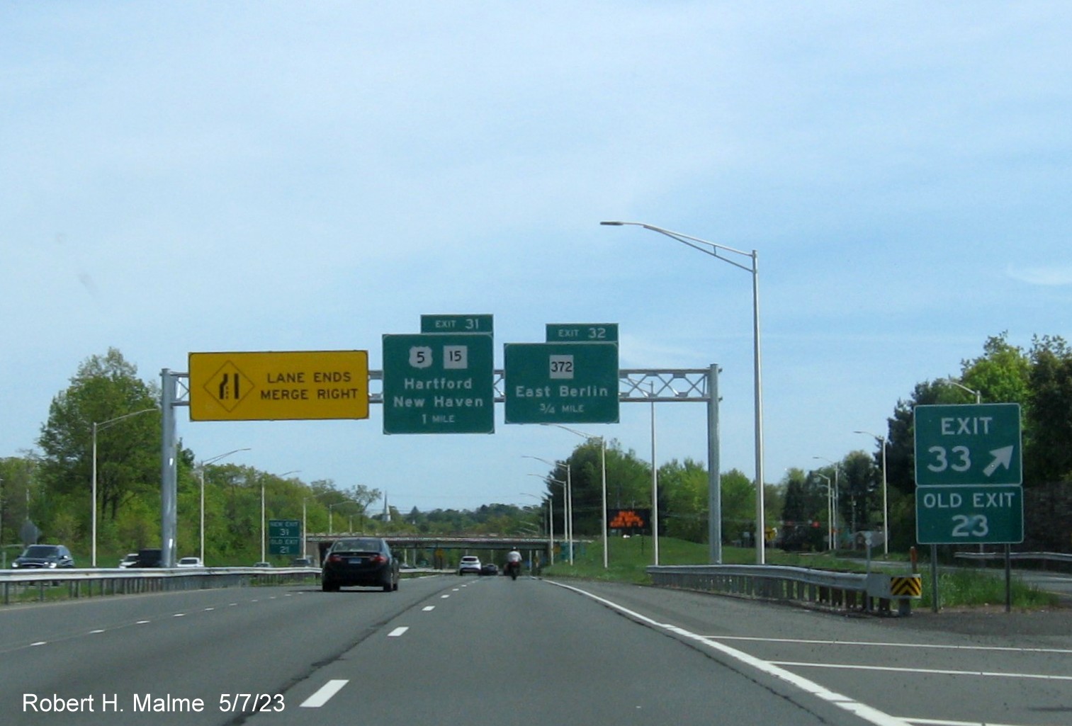 Image of ground mounted 1 Mile advance sign for Christian Lane exit with new milepost based exit number and Old Exit 23 
      sign attached below on CT 9 South in Berlin, May 2023