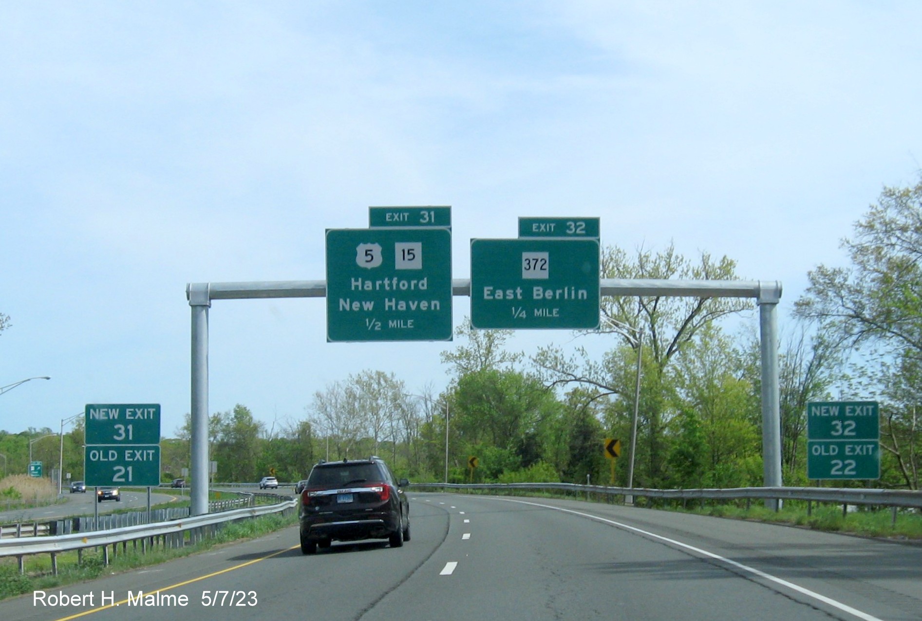 Image of 1/2 Mile advance overhead sign US 5/CT 15 and 1/2 mile advance sign for CT 372 exit with new milepost based 
        exit numbers to the left and right on CT 9 South in Berlin, May 2023