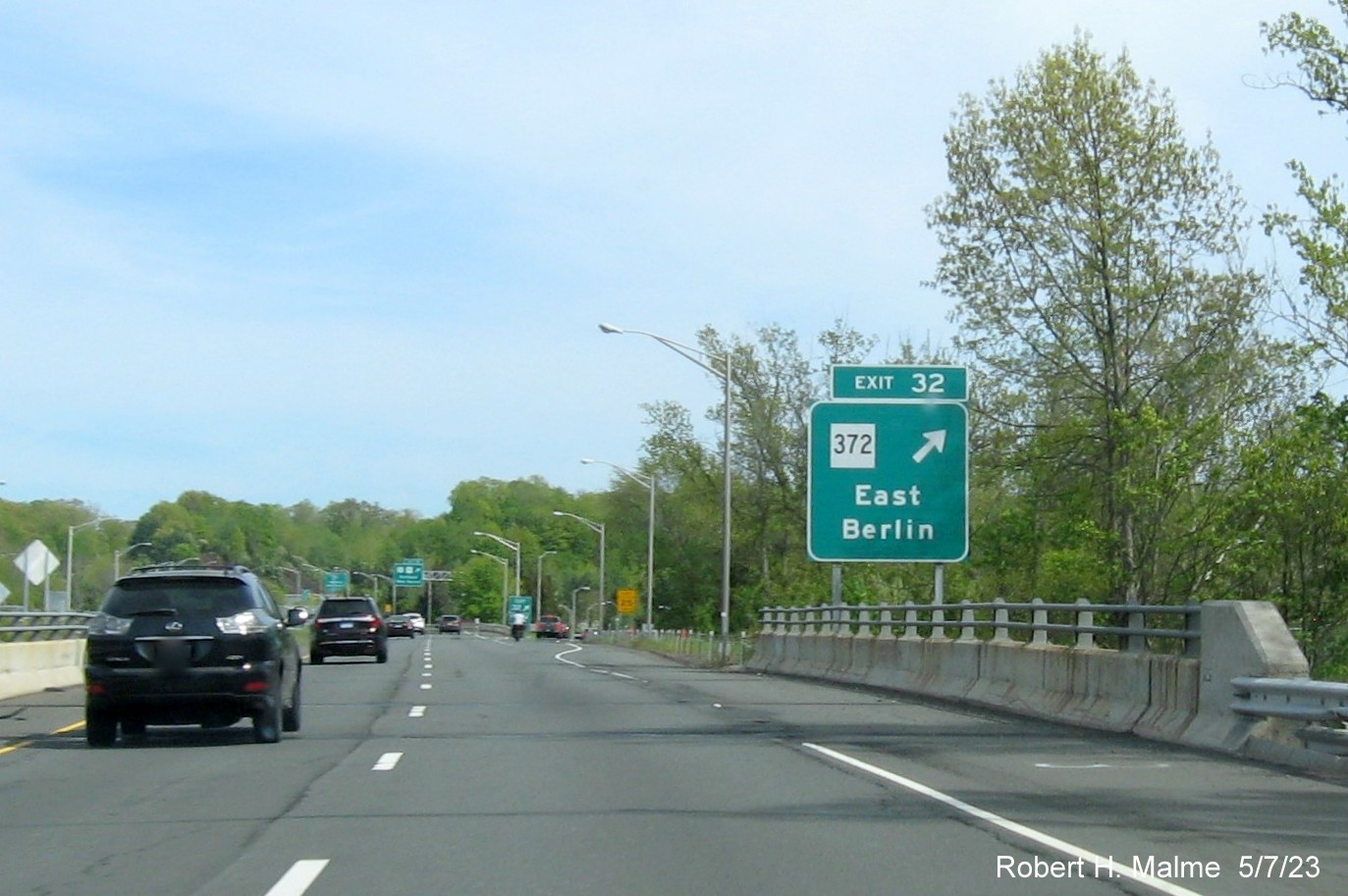 Image of overhead ramp sign for CT 372 exit with new milepost based 
        exit number and Old Exit 22 sign below on CT 9 South in Berlin, May 2023