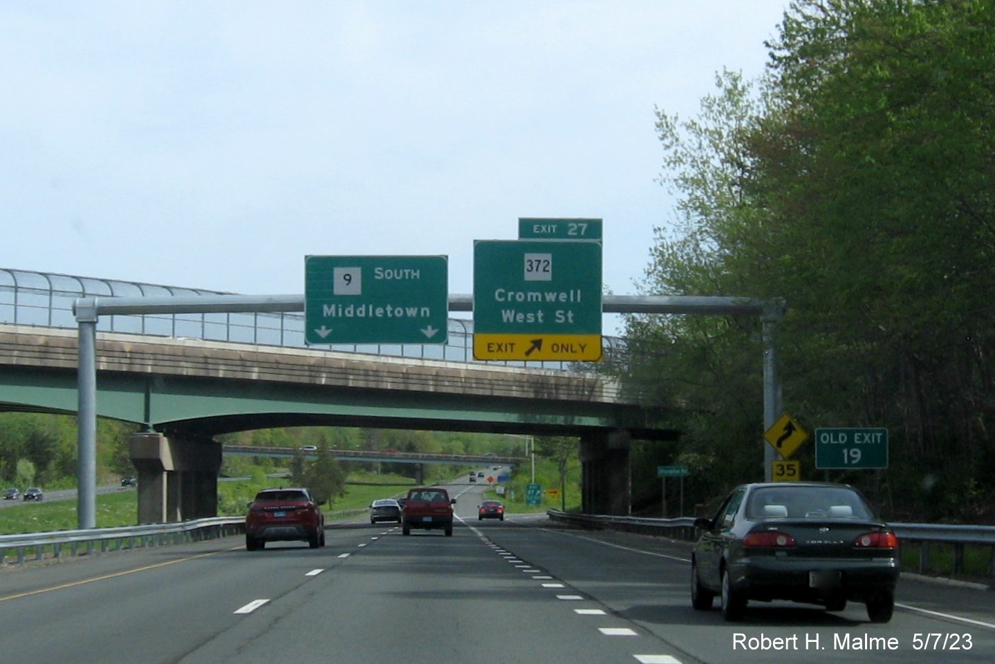 Image of overhead ramp sign for CT 372 exit with new milepost based exit number and separate 
                                     Old Exit 19 sign in front on CT 9 South in Cromwell, May 2023