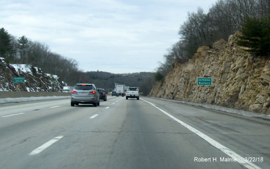 Image of new town line sign for Westboro which is missing last three letters seen on older sign to the left on I-90/Mass Pike West