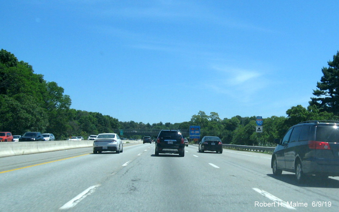 Image of recently placed ground mounted combination river crossing and jurisdictional boundary sign for Natick on I-90/Mass Pike East
