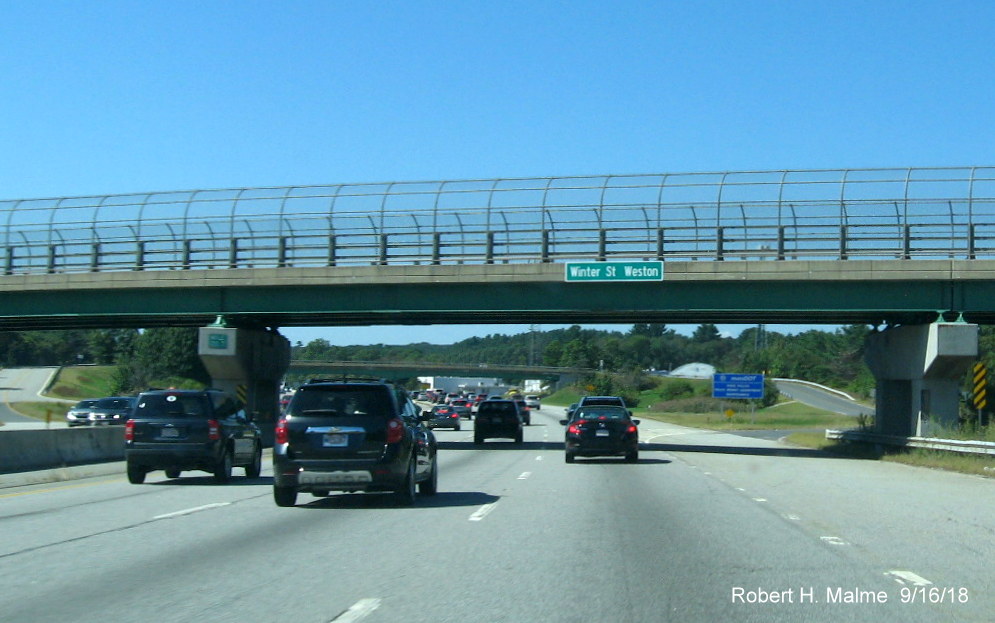 Image of a newly installed street and city name sign on bridge over I-90/Mass Pike in Weston