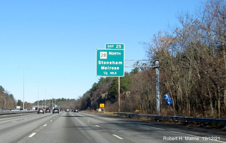 Image of 1/2 mile advance overhead sign for MA 28 Stoneham exit with new milepost based exit number on 
                                          I-93 North in Stoneham, December 2021