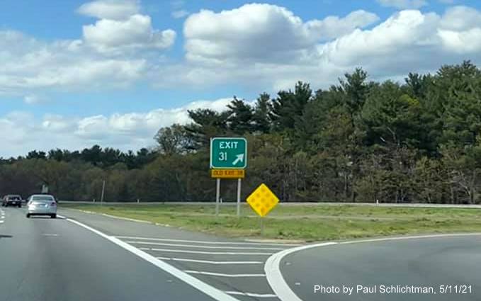 Image of gore sign for MA 129 exit with new milepost based exit number and yellow
                                           Old Exit 38 sign attached below on I-93 North in Wilmington, by Paul Schlichtman, May 2021