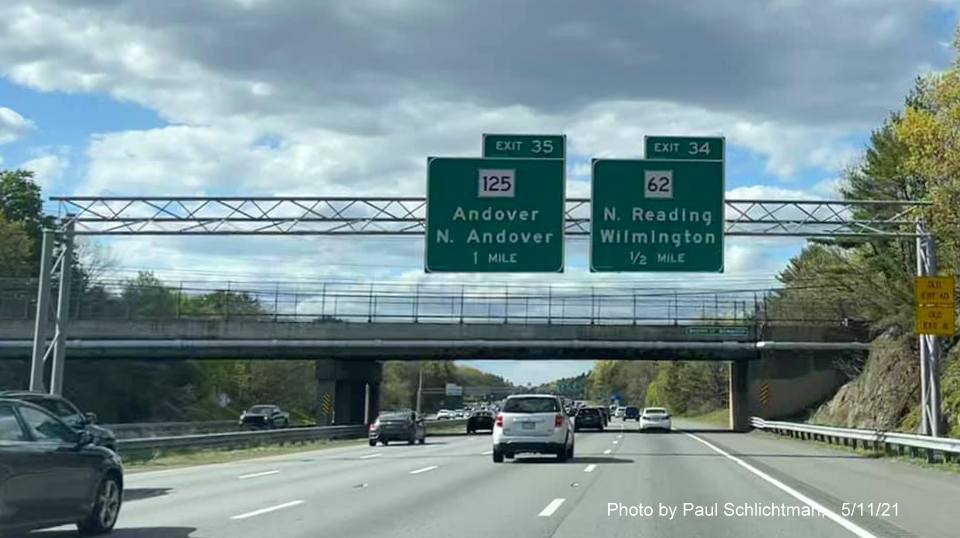 Image of overhead advance signage for MA 125 and MA 62 exits with new milepost based exit number and yellow
                                           Old Exit 40 and 41 advisory signs on right support on I-93 North in Wilmington, by Paul Schlichtman, May 2021