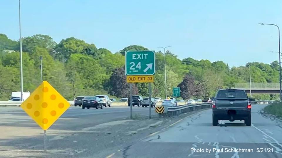 Image of gore sign for MA 28 Fellsway West exit with new milepost based exit number and yellow Old Exit 33 
                                            sign attached below on I-93 South in Medford, May 2021