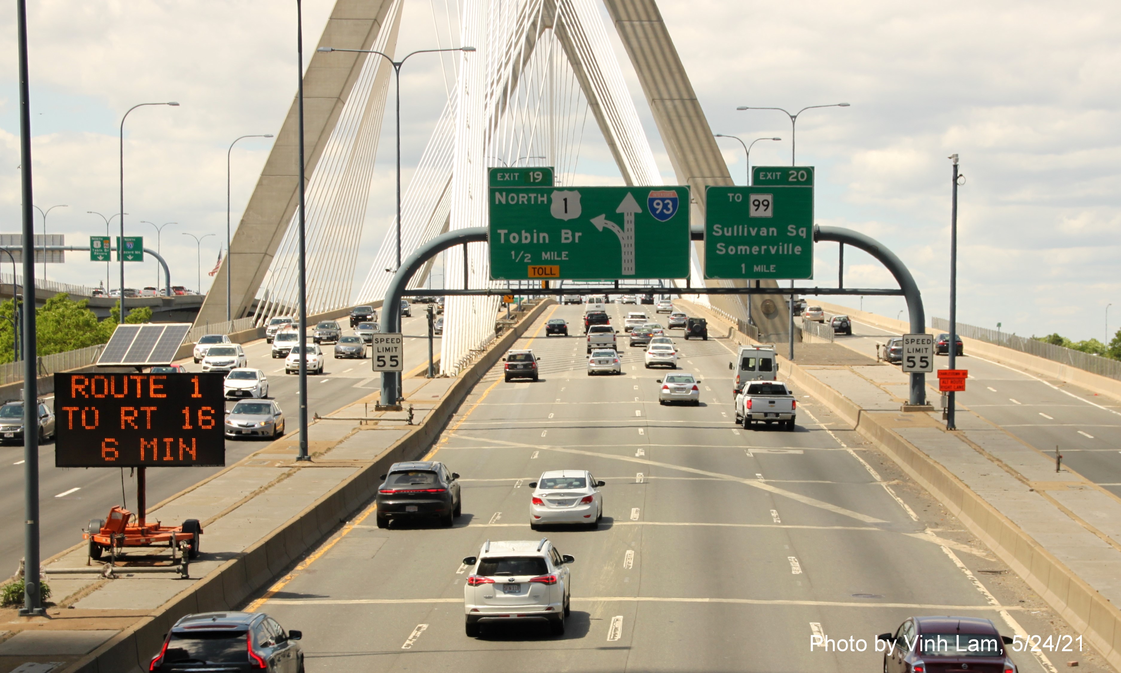Image of 1/2 mile advance sign for US 1/Tobin Bridge exit with new milepost based exit number on I-93 North from park overlooking
      O'Neill Tunnel entrance in Boston, by Vinh Lam, May 2021