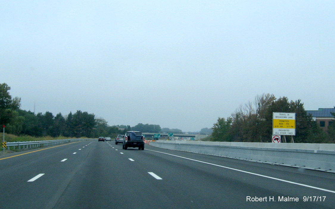Image of breakdown lane use signage beyond barrier separating future fourth lane on I-95 North in Needham