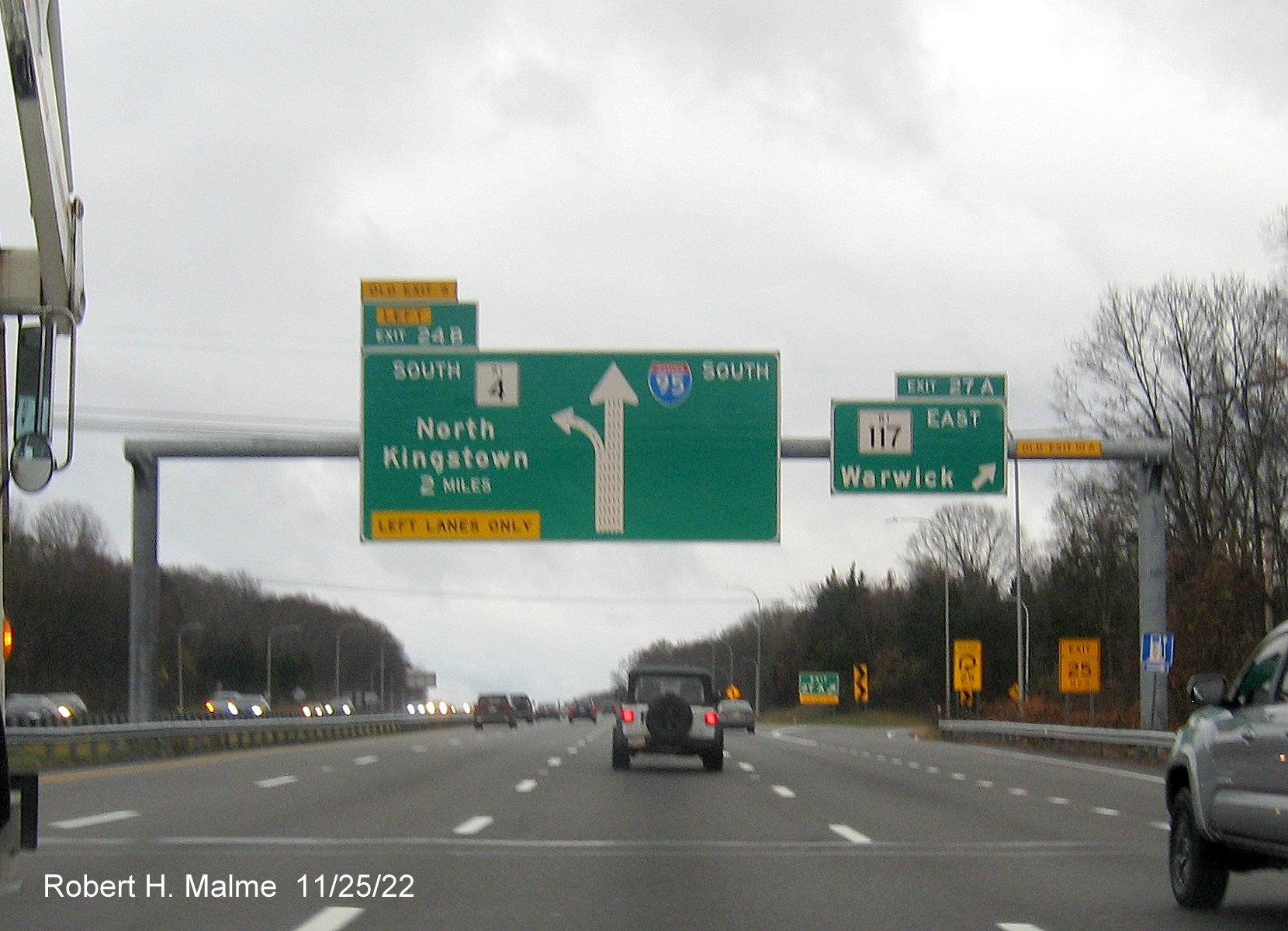Image of overhead ramp sign for RI 117 East exit with new milepost based exit numbers and yellow Old Exit 10B sign on right gantry arm on I-95 South in Warwick, November 2022