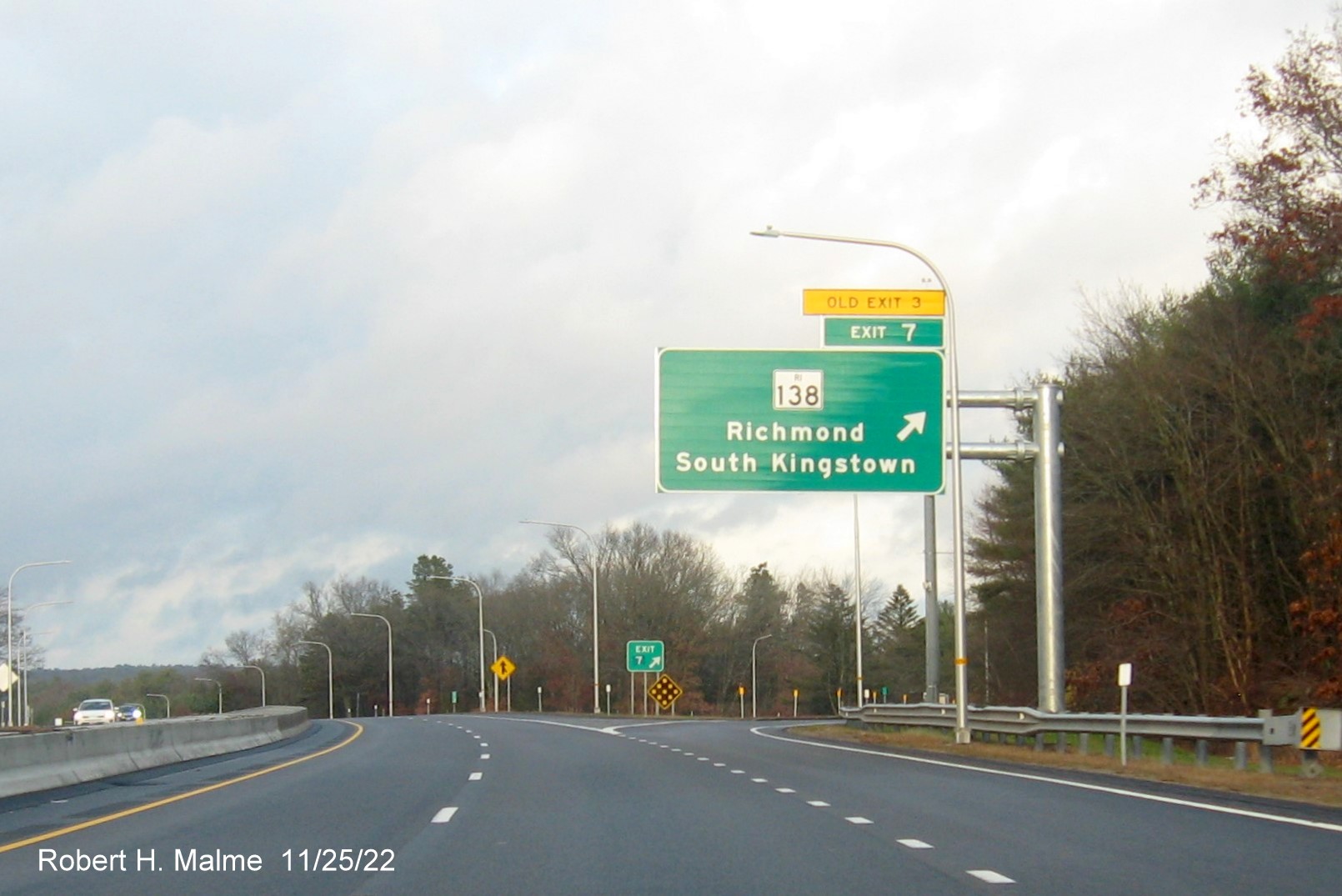Image of overhead ramp sign for RI 138 exit with new milepost based exit number and 
                                         yellow Old Exit 3 sign above exit tab on I-95 North in Wyoming, November 2022