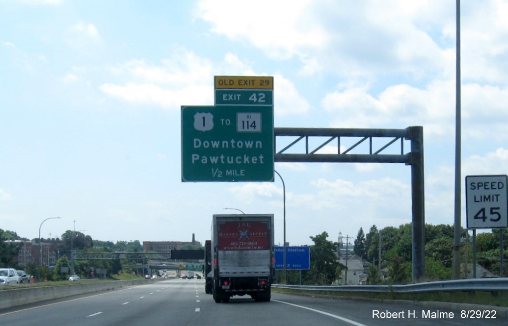 Image of 1/2 mile advance overhead sign for US 1 to RI 114 exit with new milepost based exit number and 
                                          yellow Old Exit 29 sign placed above the exit tab on I-95 South in Pawtucket, August 2022
