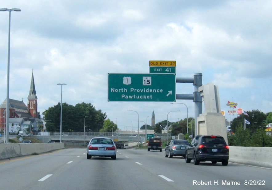 Image of overhead ramp and gore signs for US 1/RI 15 exit with new milepost based exit number 
      and yellow Old Exit 27 signs on I-95 South in Pawtucket, August 2022