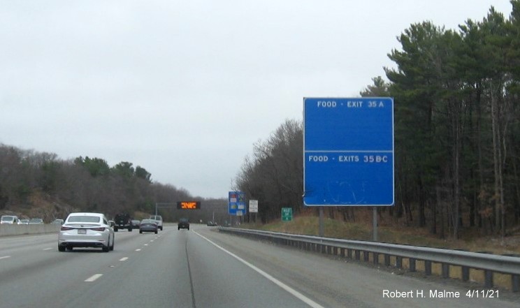 Image of blank blue Food Service sign for Kendrick Street and Highland Avenue exits with new milepost 
                                            based exit numbers on I-95/MA 128 North in Needham, April 2021