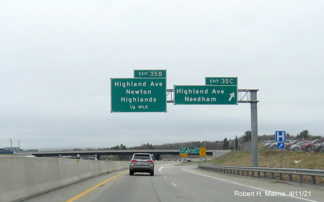 Image of overhead ramp sign for Highland Avenue exits with new milepost based 
                                            exit numbers on C/D ramp from I-95/MA 128 South in Needham, April 2021