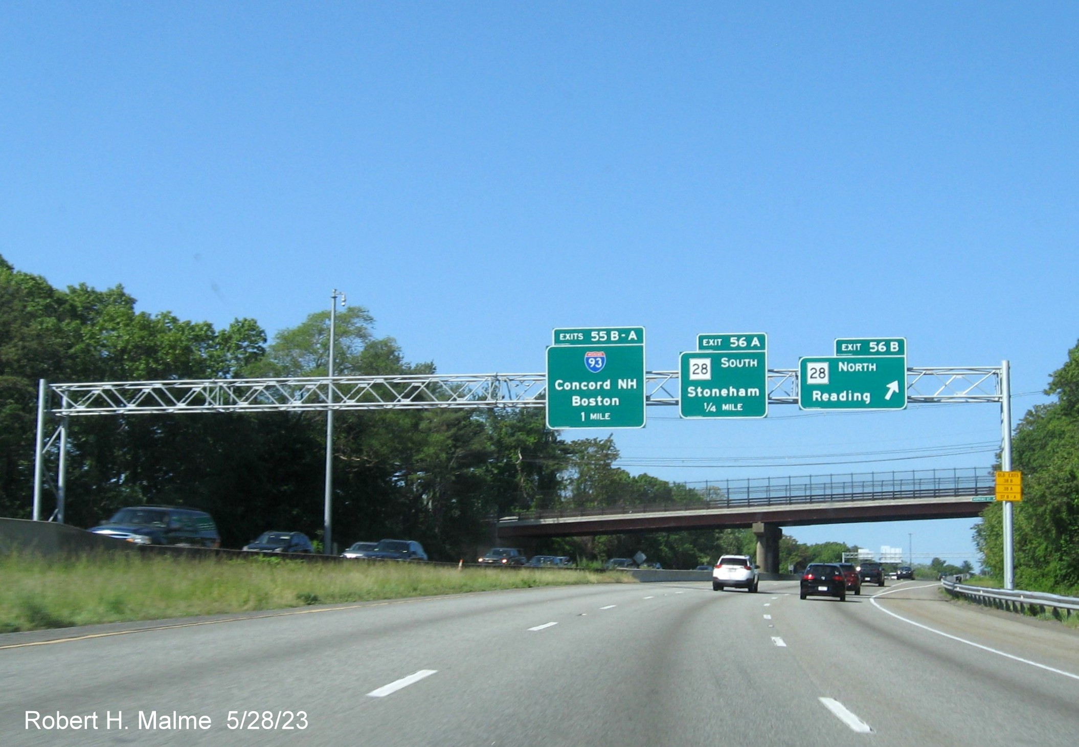 Image of recently placed overhead signage for MA 28 and I-93 exits at ramp for MA 28 North on I-95 South 
        in Reading, May 2023