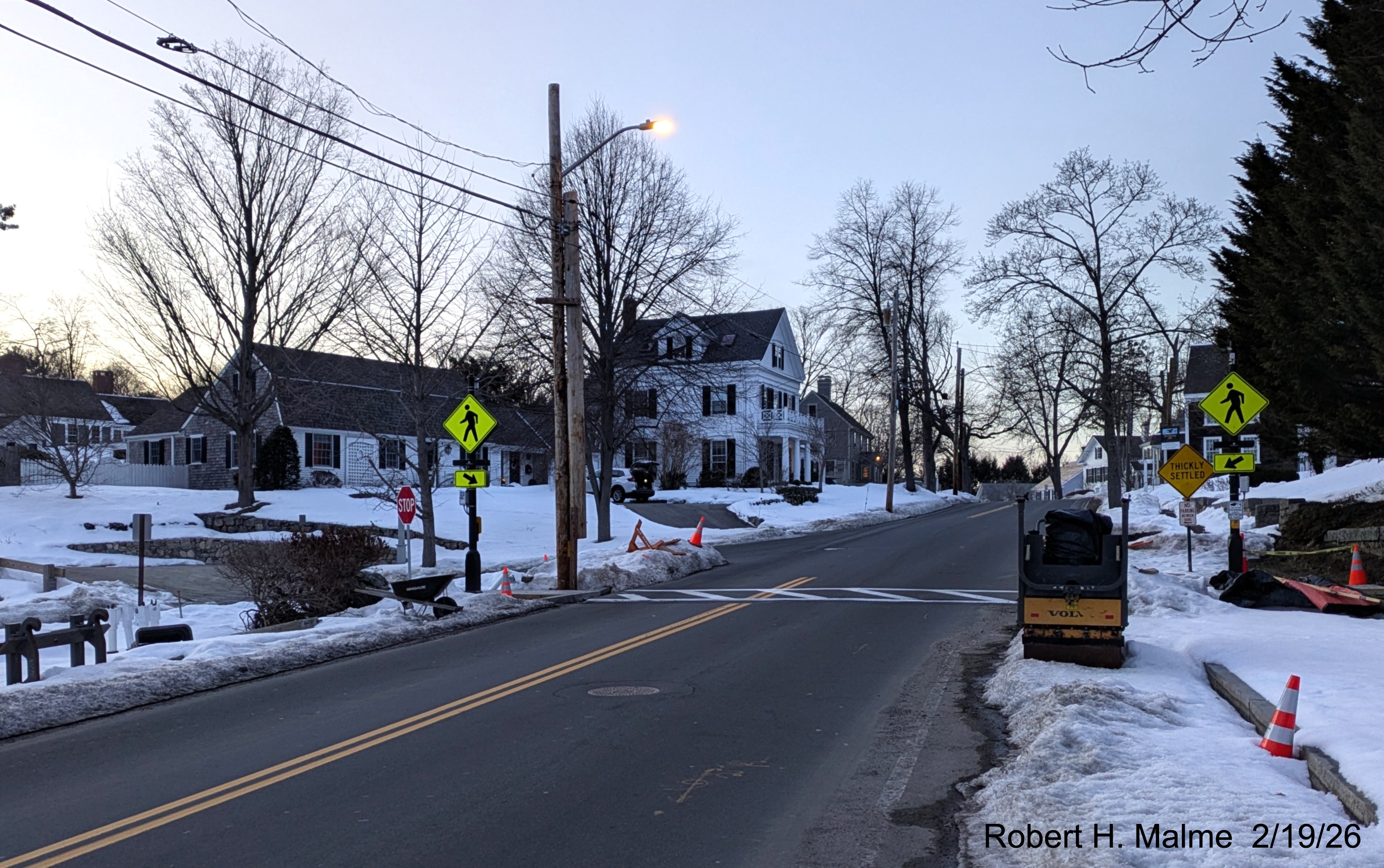 Image of new pedestrian crosswalk now with lines painted across Lincoln Street looking 
	north with added pedestrian crossing signs on the light poles, February 2026