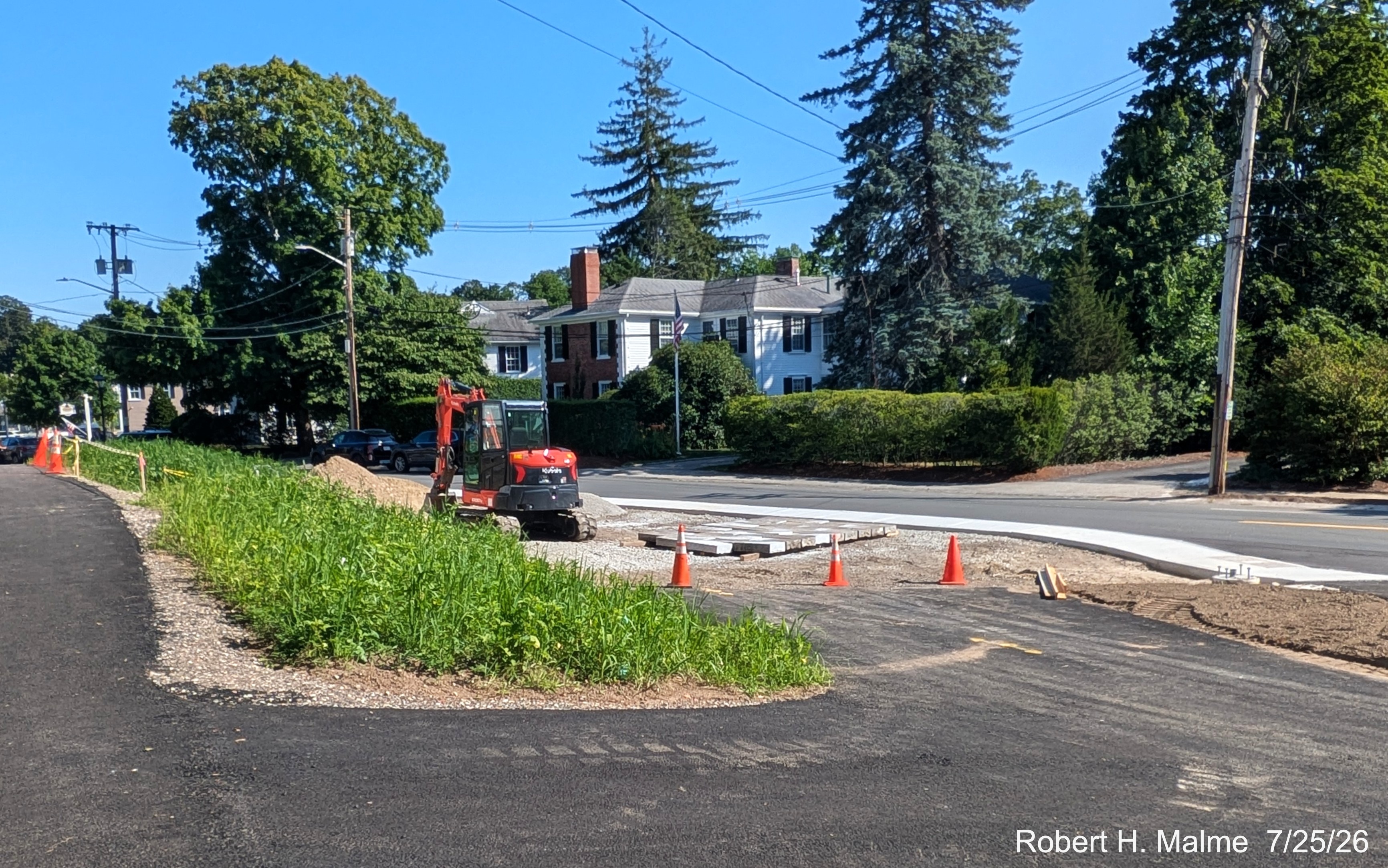 Image taken looking south from the Lincoln and North Street intersection showing work still 
	continuing in front of the New North Church, and weeds overwhelming the site, July 2026