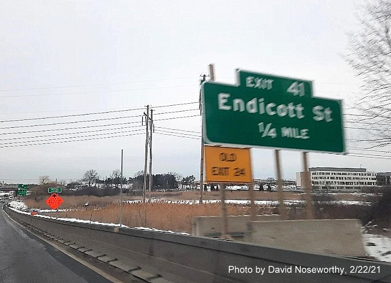 Image of ground mounted 1/2 mile advance sign for the Endicott Street exit with new milepost 
      based exit number and yellow old exit sign on the right support post on MA 128 North in Danvers, photo by David Noseworthy, February 2021