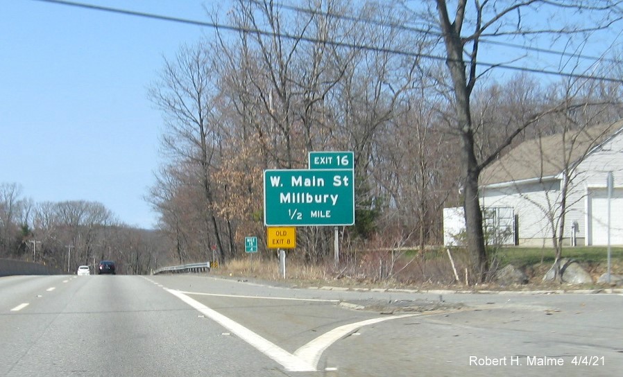 Image of overhead advance sign for West Main Street exit with new milepost based exit number and yellow Old Exit 8 advisory sign on left support on MA 146 North in Millbury, April 2021