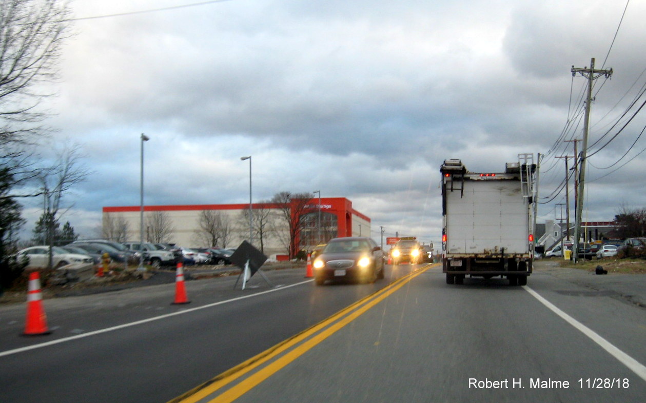 Image of paved future northbound lane on MA 18 north as seen heading south of commuter rail bridge in widening project work zone in Weymouth