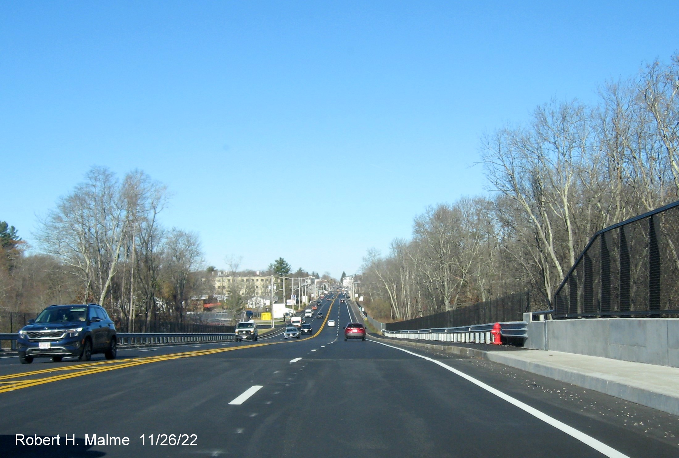Image of MA 18 North traffic heading down completed commuter railroad bridge in South Weymouth, November 2022