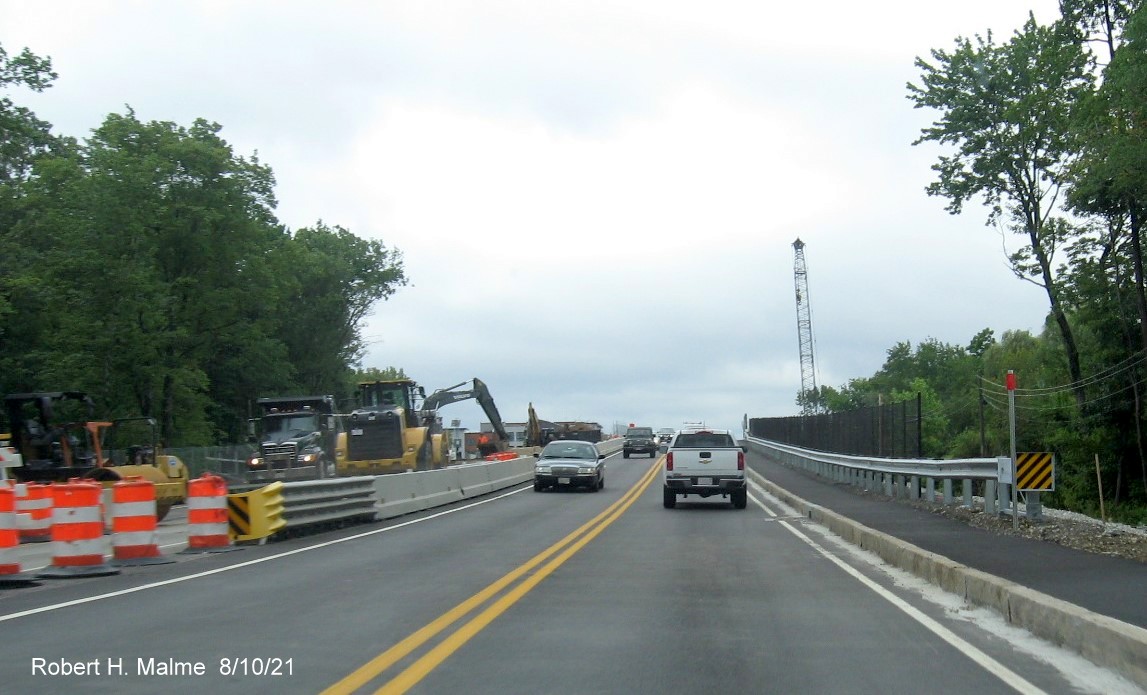 Image of traffic on MA 18 South at bottom of commuter railroad bridge still under construction in South 
     Weymouth, August 2021