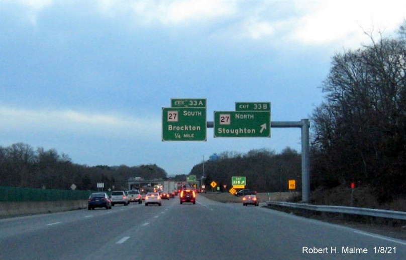 Image of overhead signs for MA 27 exits at ramp to MA 27 North with new milepost based exit number 
                                      and gore sign with yellow old exit number sign below on MA 24 South in Brockton, January 2021