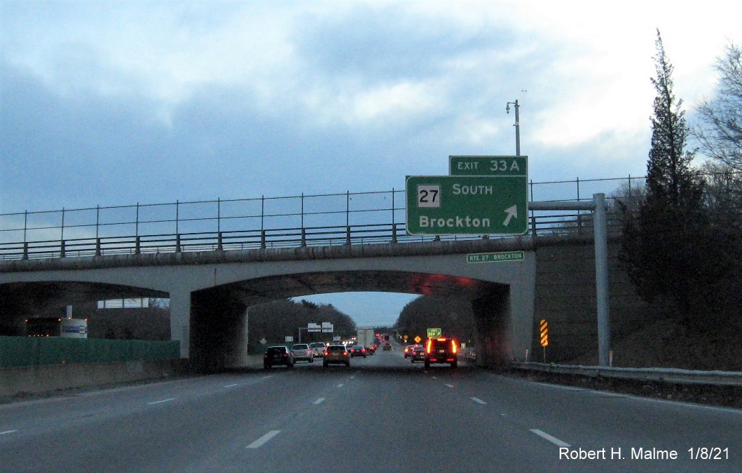 Image of overhead ramp sign for MA 27 South exit with new milepost based exit number 
                                      and gore sign with yellow old exit number sign below on MA 24 South in Brockton, January 2021