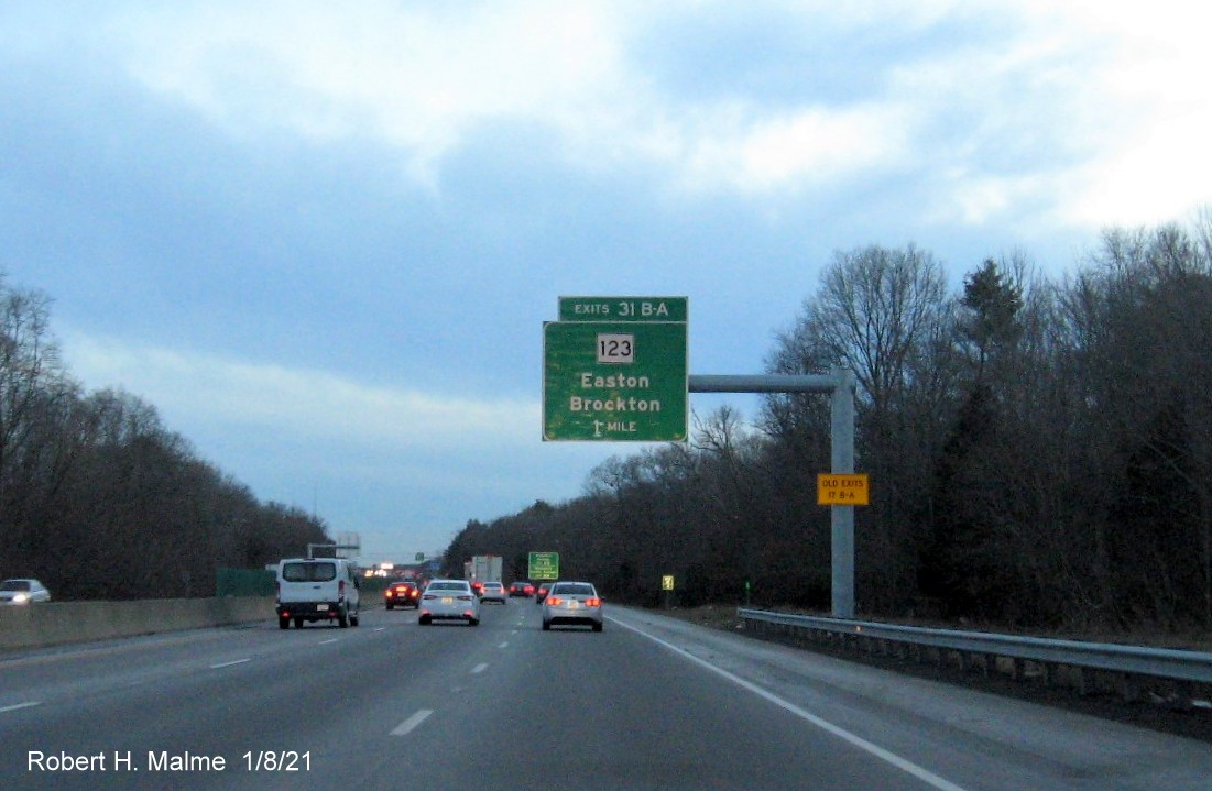 Image of 1 mile advance overhead sign for MA 123 exits with new milepost based exit number 
                                      and yellow old exit number sign on support post on MA 24 South in Brockton, January 2021