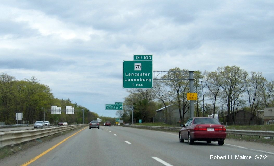 Image of 1 mile advance overhead sign for MA 70 exit with new milepost based exit number and yellow Old Exit 35 advisory sign on support on MA 2 East in Lancaster, May 2021