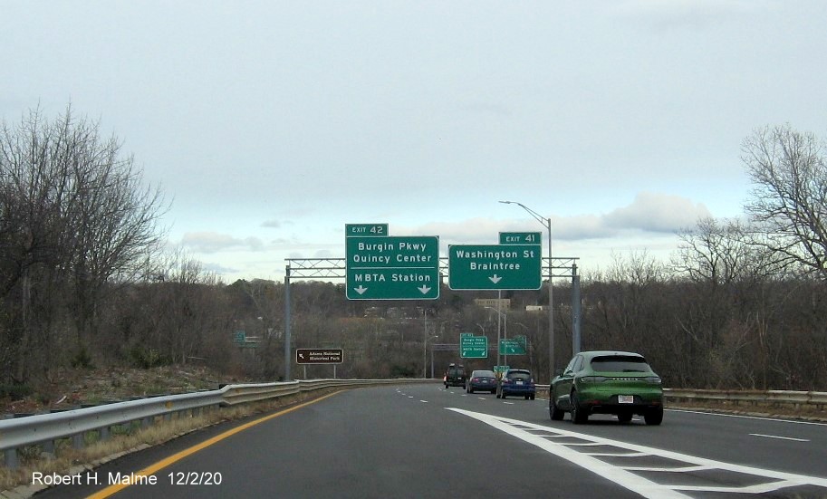 Image of overhead signs on ramp from MA 3 South to Burgin Parkway/Washington Street exits with new milepost exit 
    numbers in Braintree, December 2020