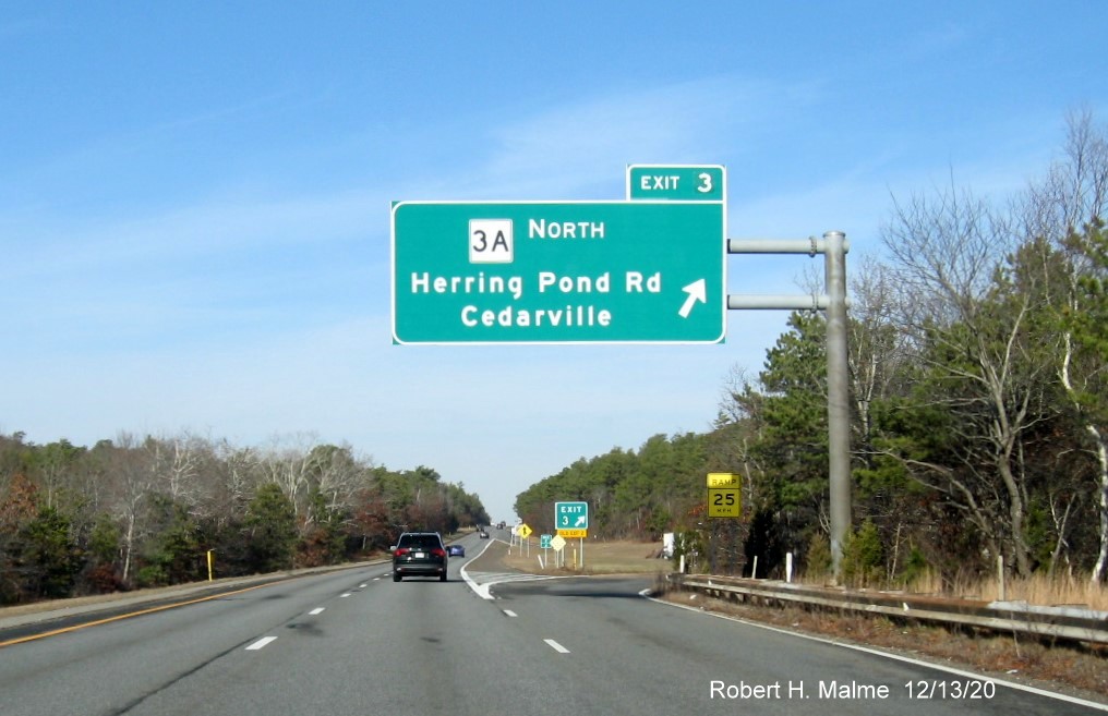 Image of overhead ramp sign for MA 3A North exit with new milepost based exit number and gore sign with new number and yellow old exit number tab below on MA 3 North in Plymouth