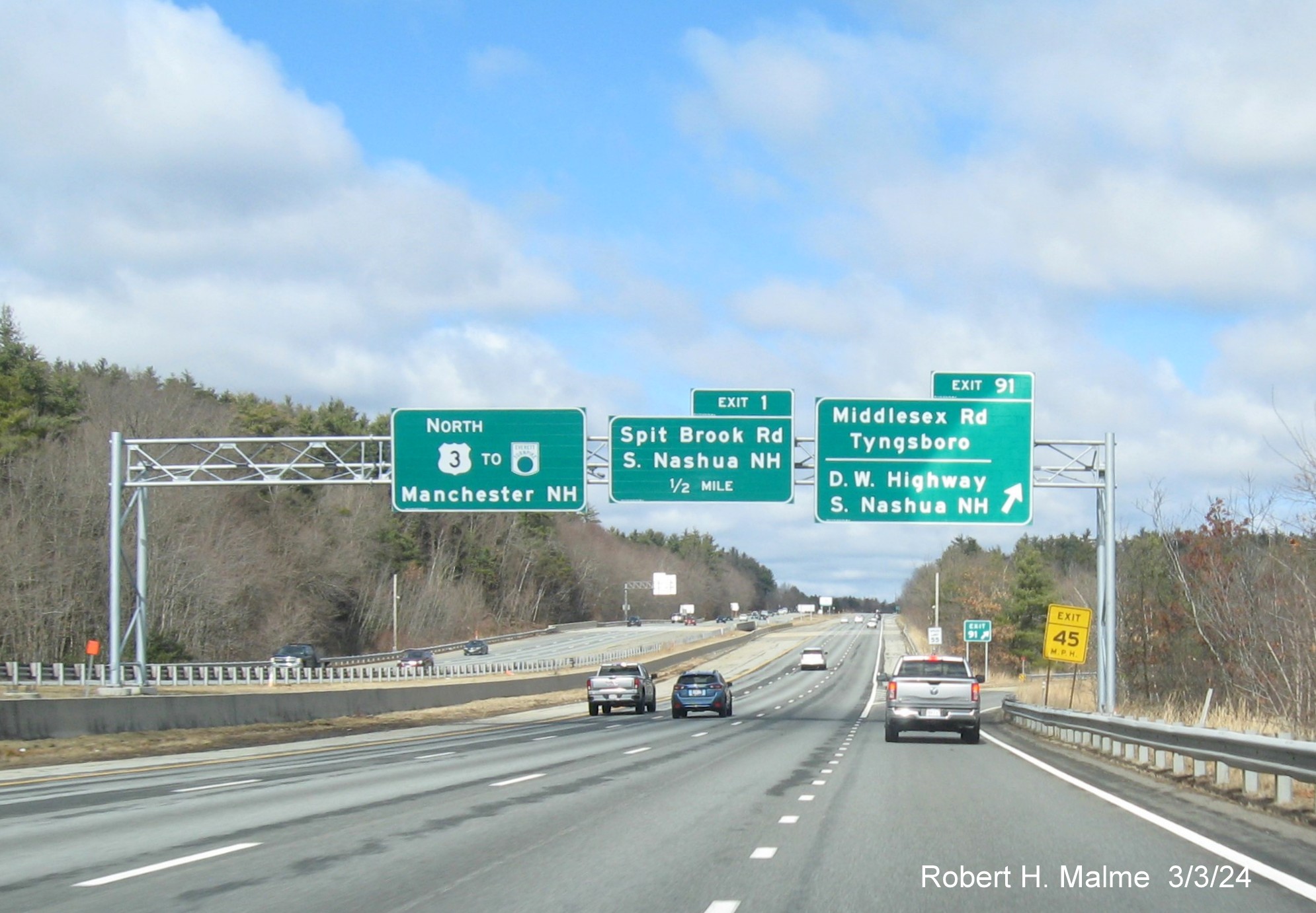 Image of recently placed overhead ramp sign for Middlesex Road exit on US 3 North in Tyngsboro, along
      with signs for NH exit, March 2024