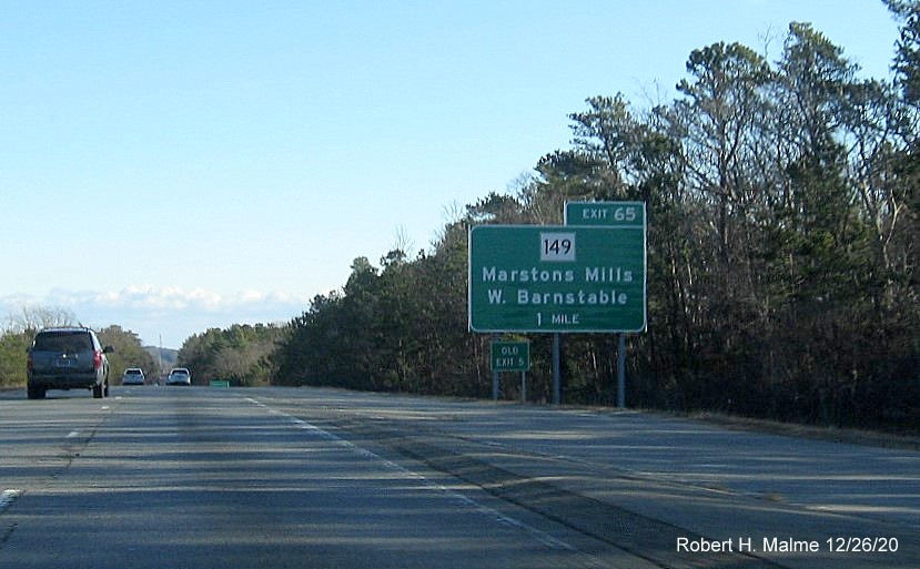 Image of 1-mile advance sign for MA 149 exit with new milepost based exit number and green old exit number sign on left support post on US 6 East in Barnstable, December 2020