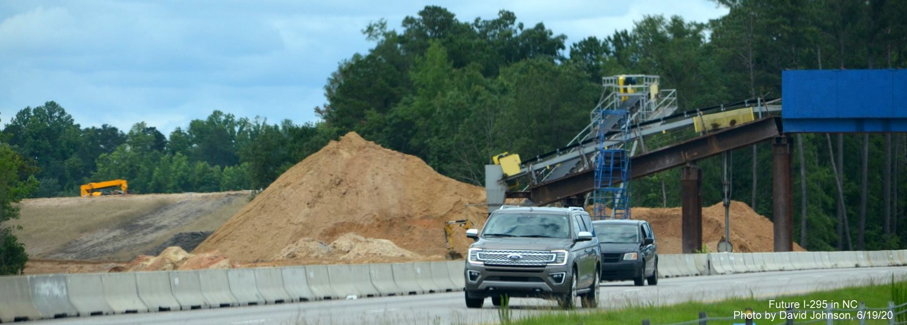 Image of dirt pile moved by conveyor belt across I-95 at future I-295 interchange near Hope Mills, by 
        David Johnson June 2020