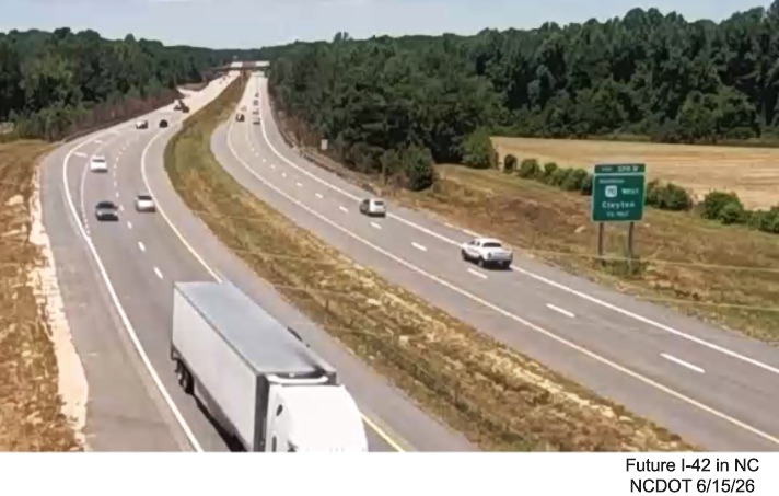 NCDOT traffic camera image of blue services sign for the Swift Creek Road exit with
	US 70 milepost exit number on US 70 (Future I-42) East in Wilson's Mills, June 2026