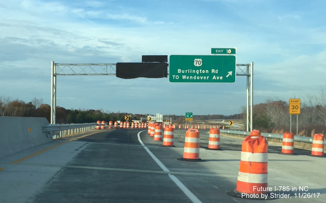 Image of new overhead exit signs for US 70 and for Huffine Mill Rd, covered over, on I-785 North 
           in Greensboro, by Strider