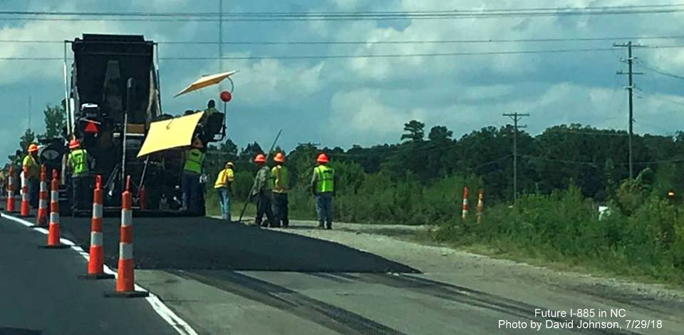 Image of workers laying down pavement along split of current US 70 with future East End Connector alignment in Durham, by David Johnson