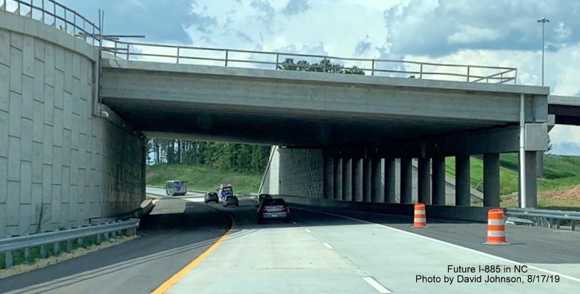 Image of traffic on new NC 147 lanes approaching underpass of Future I-885 South lanes at East End Connector interchange in Durham, by David Johnson