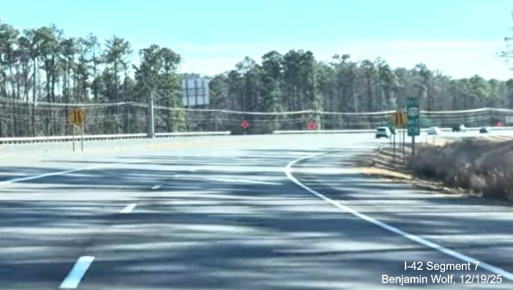 Image of East Business US 70 merging with opened lanes from US 70 (Future I-42) East 
	at the eastern end of the Havelock Bypass, Screen grab from Benjamin Wolf video, December 2025