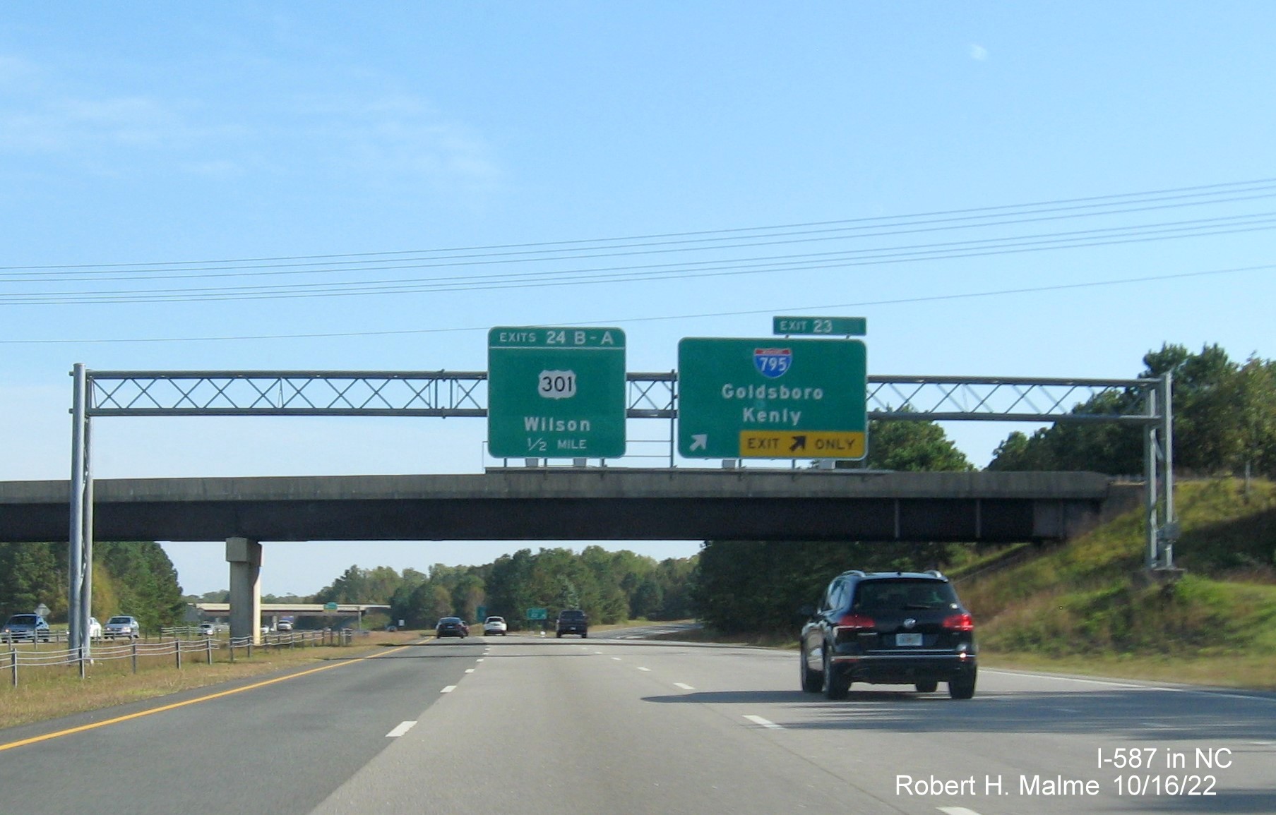 Image of overhead signage at ramp for I-795 South exit with new I-587 milepost exit number on I-587/US 264 East,I-795 
                                        South in Wilson, October 2022
