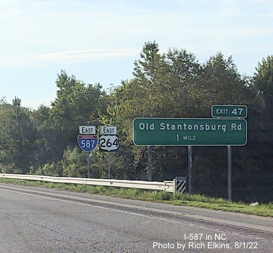 Image of new East I-587 reassurance marker in Wilson with US style direction banner, and unchanged 
      exit number on 1 mile advance sign for Old Stantonburg Road exit, photo courtesy of Rich Elkins, August 2022