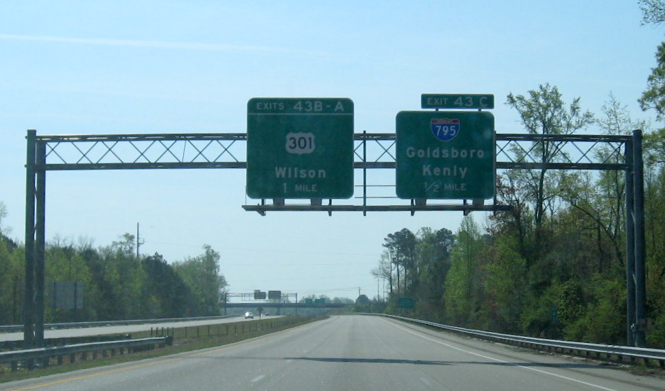 Photo of I-795 Exit sign on US 264 East and auxiliary signage for US 117 traffic, 
        April 2010