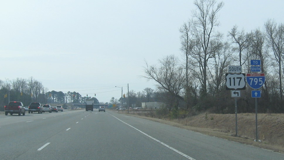 Photo of signage on US 301 south that distinguish between intersection for US 
           117 back on its old route, and I-795 on the former US 117 freeway, Jan. 2010