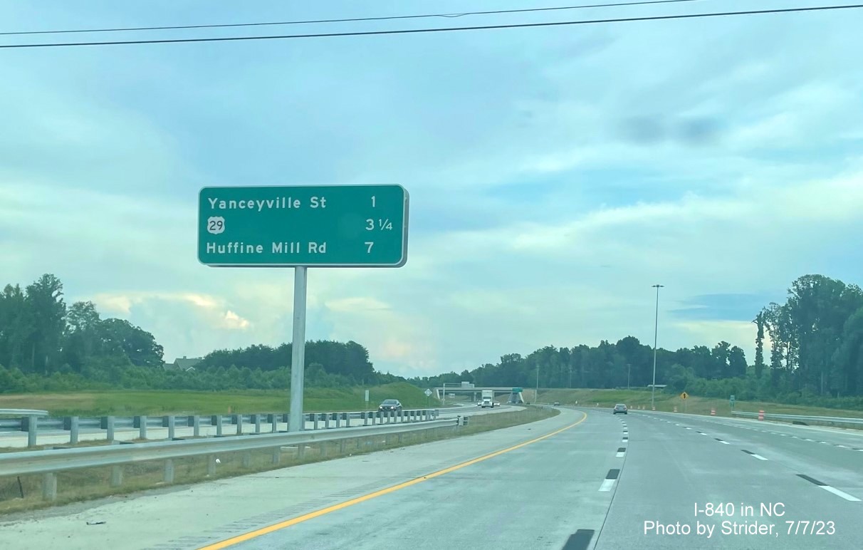 Image of newly placed median post-interchange distance sign along I-840 East beyond the North Elm Street exit, photo by Strider, July 2023